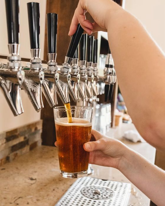 A bartender pouring a pint from the tap